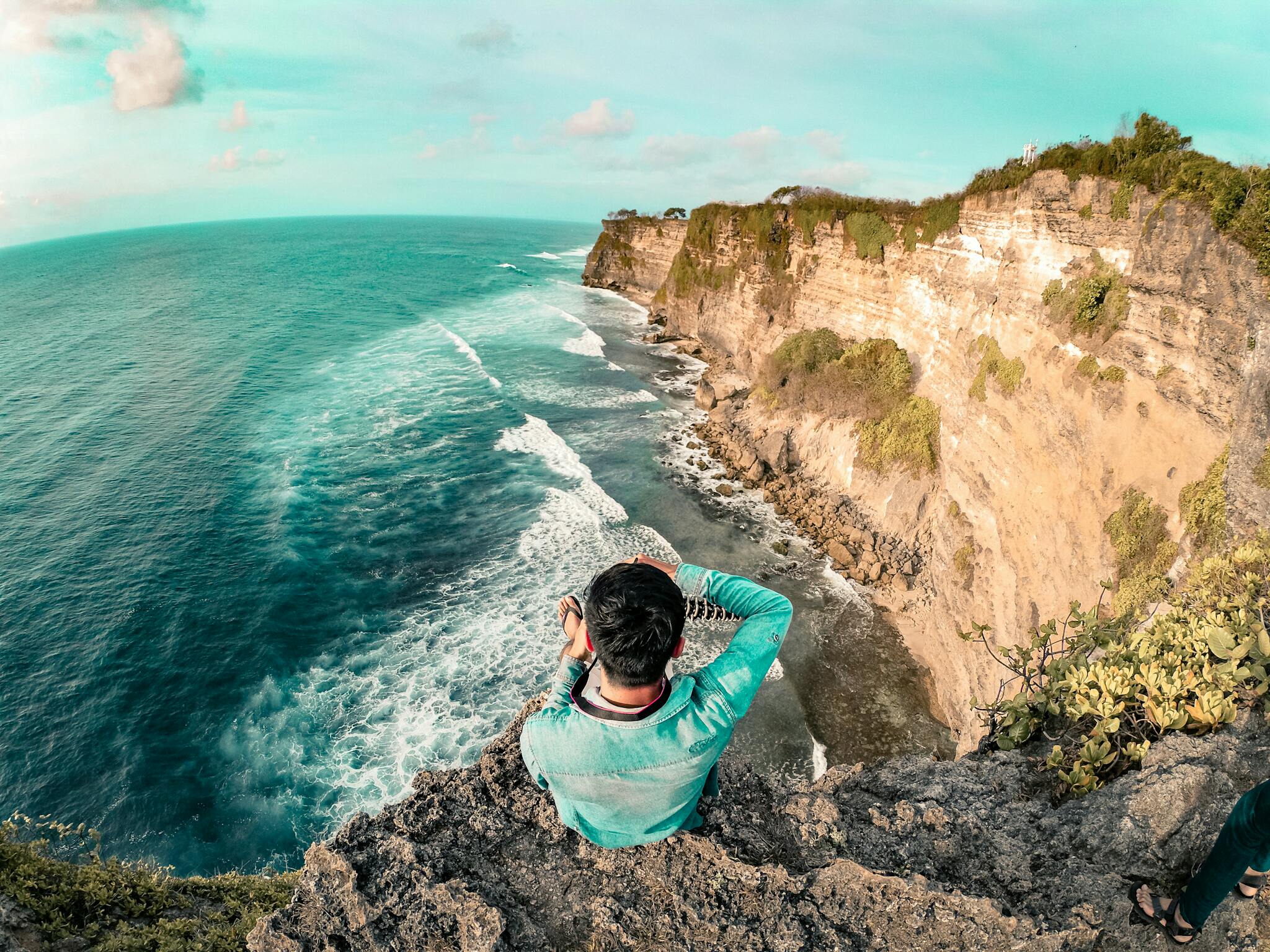 Man Wearing Blue Long Sleeve Top On Top Of Mountain Near Body Of Water